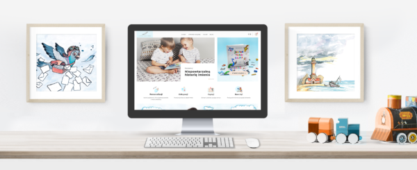monitor z otwartym sklepem internetowym Jedyna Taka Bajka na biurku, obok zabawka pociąg