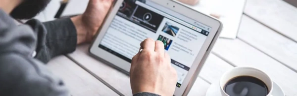 mężczyzna z abletem w ręku przegląda stronę internetową
