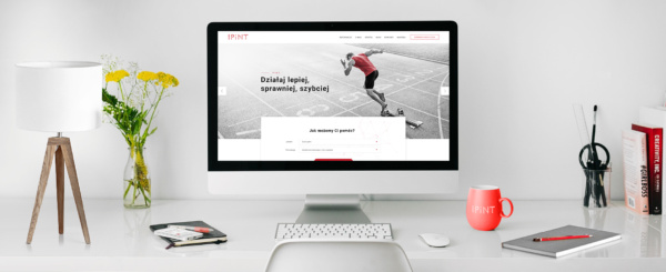 monitor z otwartą stroną internetową firmy IPINT na biurku