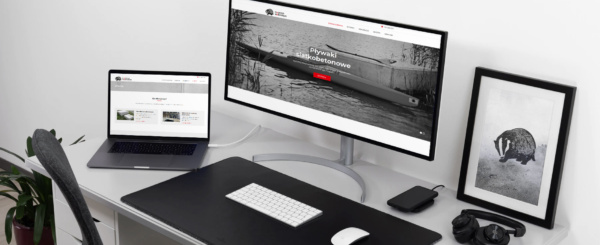 laptop i monitor z otwartą stroną internetową firmy Majster Warmiński na biurku