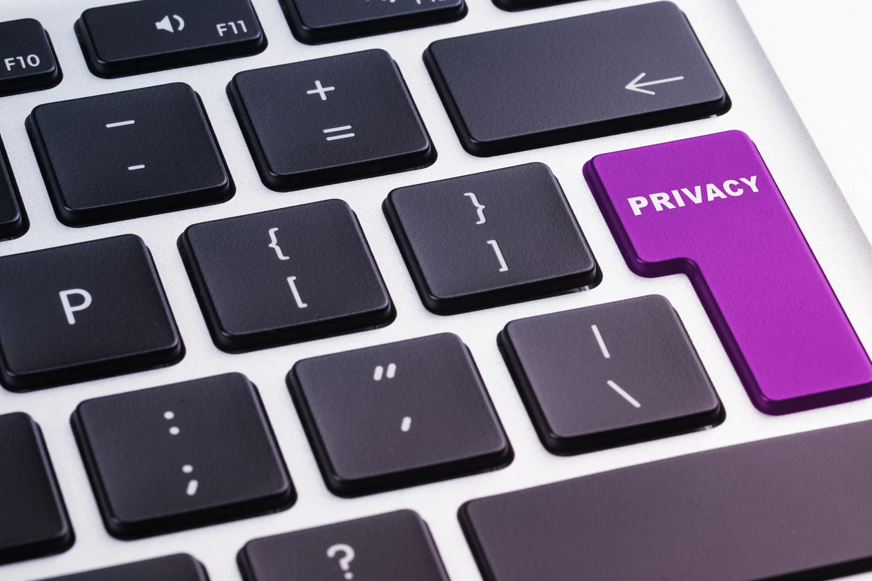 Zbliżenie na klawiaturę komputera z wyróżnionym fioletowym przyciskiem z napisem Privacy