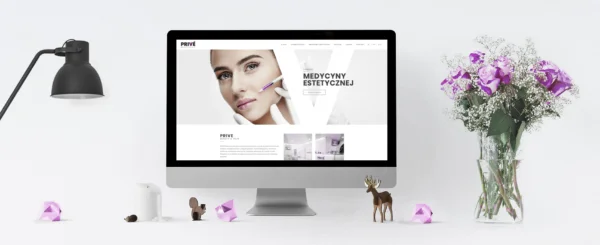 monitor z otwartą stroną internetową gabinetu kosmetycznego Prive Beauty&Hair, obok lampa i wazon z kwiatami