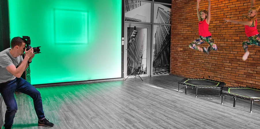 Fotograf robiacy zdjecie dwiema kobietom skaczacym na trampolinach fitness