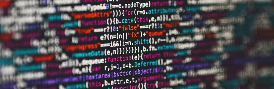 Kolorowy kod źródłowy programowania na ciemnym ekranie, zbliżenie i efekt głębi ostrości
