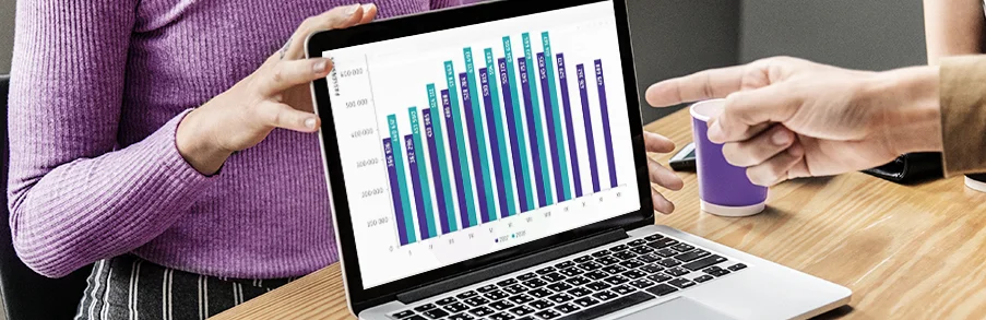 Prezentacja raportu ze wzrostem sprzedaży na ekranie laptopa podczas spotkania biznesowego