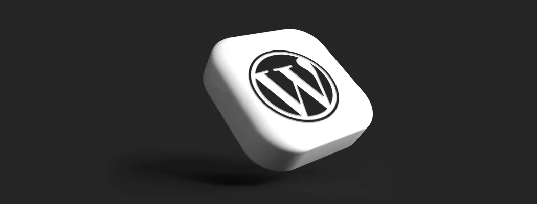 Trójwymiarowa biała ikona z logo WordPress na ciemnoszarym tle.