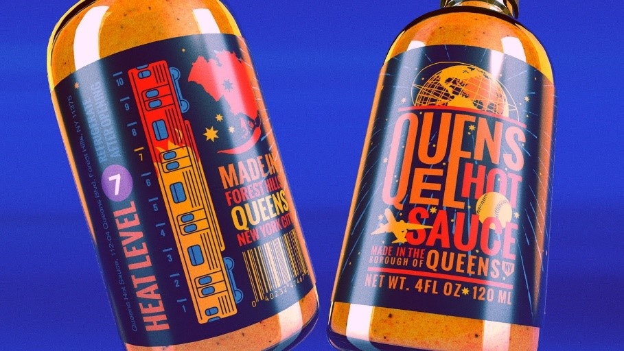 Dwie szklane butelki ostrości sosu Queens Hot Sauce z retro etykietami nawiązującymi do Nowego Jorku
