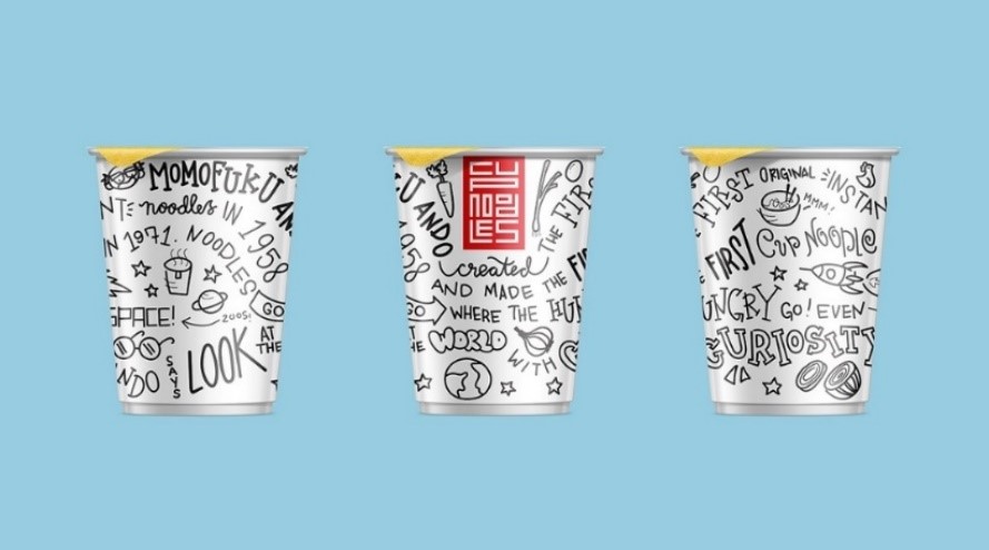 Trzy papierowe kubki na makaron Cup Noodles pokryte czarno-białymi rysunkami typu doodle