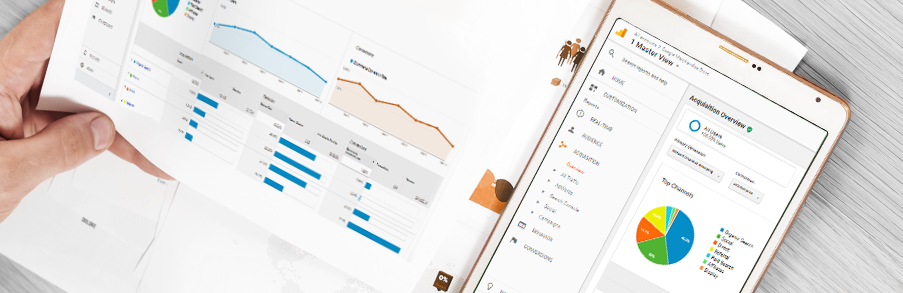 Zbliżenie na dłoń trzymającą kartkę z wykresami danych, obok smartfon z aplikacją Google Analytics na ekranie
