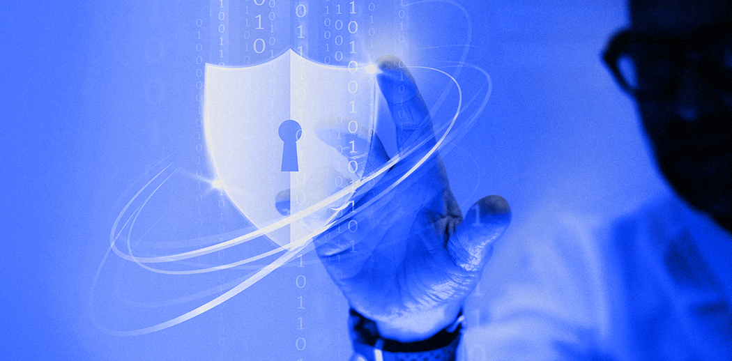 Mężczyzna dotykający cyfrowej tarczy bezpieczeństwa z dziurką od klucza i kodem binarnym – koncepcja cyberbezpieczeństwa i ochrony danych w sieci.