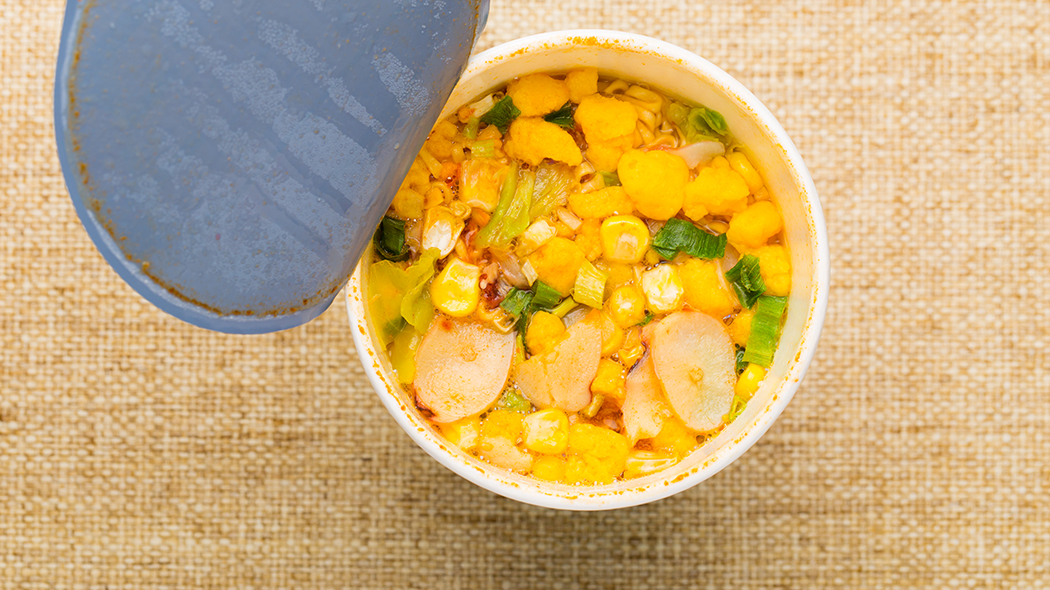 zdrowy fast food zupa jarzynowa w kubku stojąca na bawełnianym obrusie