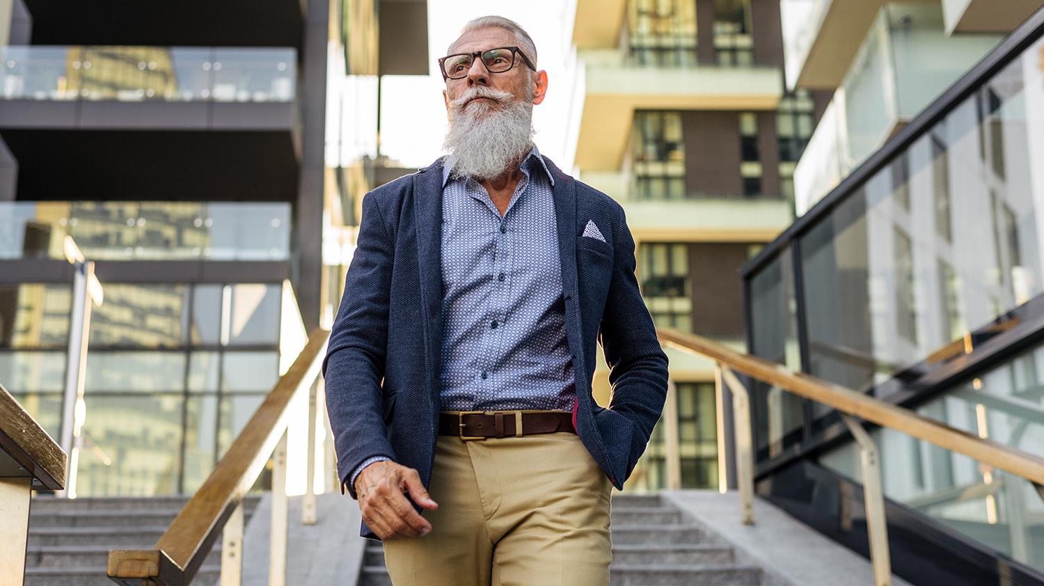 elegancki biznesman w średnim wieku Dojrzały mężczyzna elegancko ubrany i wystylizowany wśród współczesnej architektury