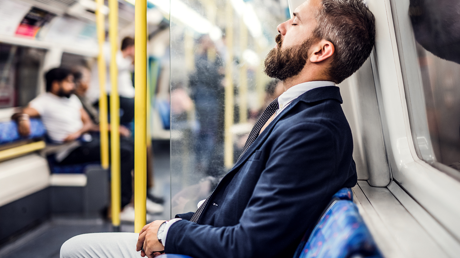 Zmęczony mężczyzna w metrze Silnie zmęczony mężczyzna ubrany w marynarkę i krawat wraca do domu metrem