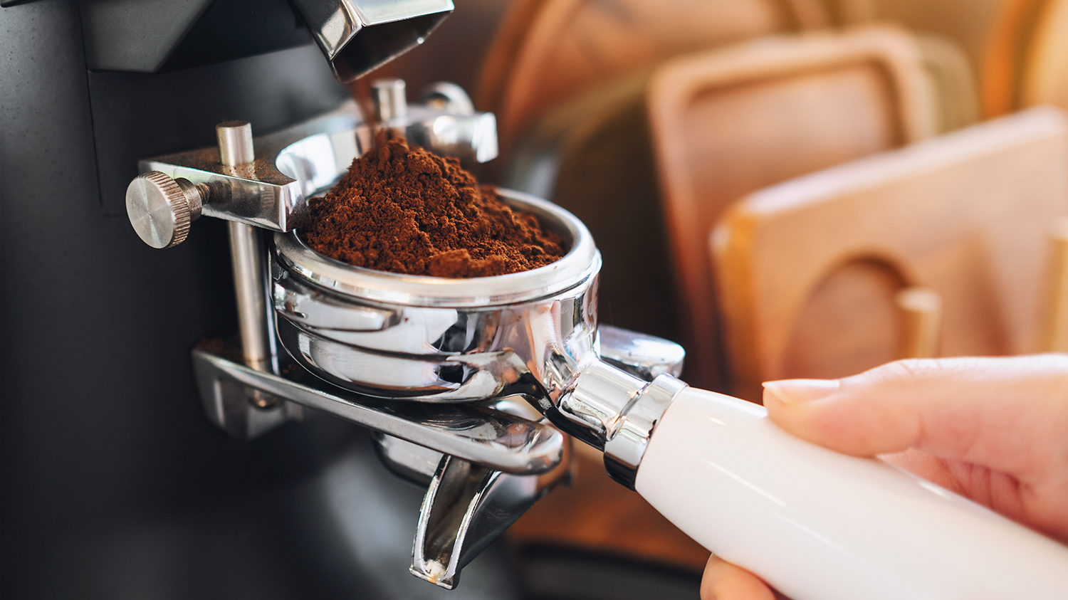 Specjalistyczny ekspres do kawy Barista wkłada zmieloną kawę do specjalistycznego ekspresu.